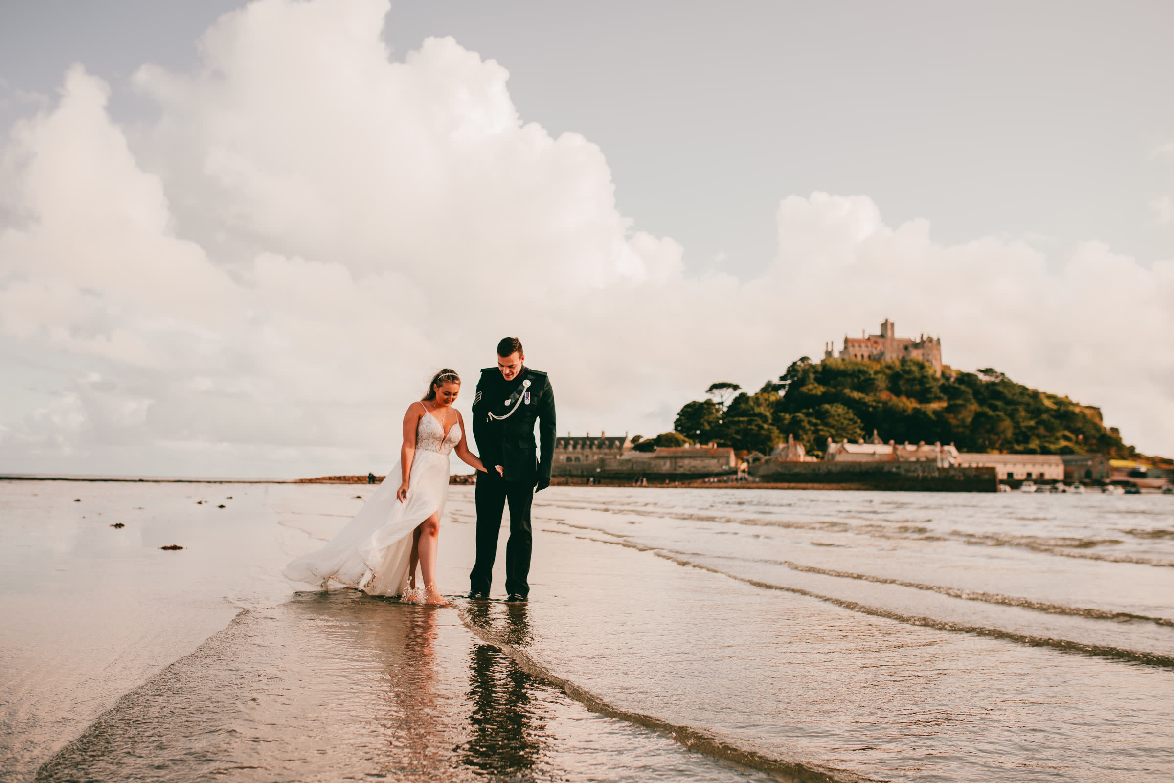 A couple on the sands at low tide with St Michael's Mount in the distance